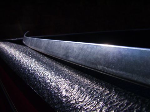1982 Ford Crown Victoria LTD - A close-up shot focuses on a metallic trim piece and a textured surface, likely part of a vehicle's interior or exterior.
