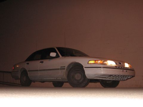 1992 Ford Crown Victoria - A white Ford Crown Victoria is shown from the front-right angle at night.