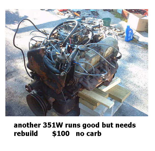 Used Ford 351W V8 engine for sale sitting on pavement with parts