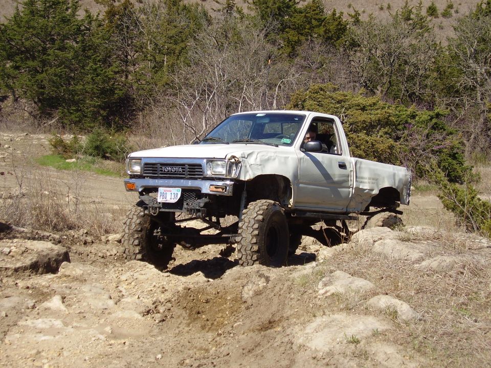 Lifted silver Toyota pickup on rocky off-road terrain