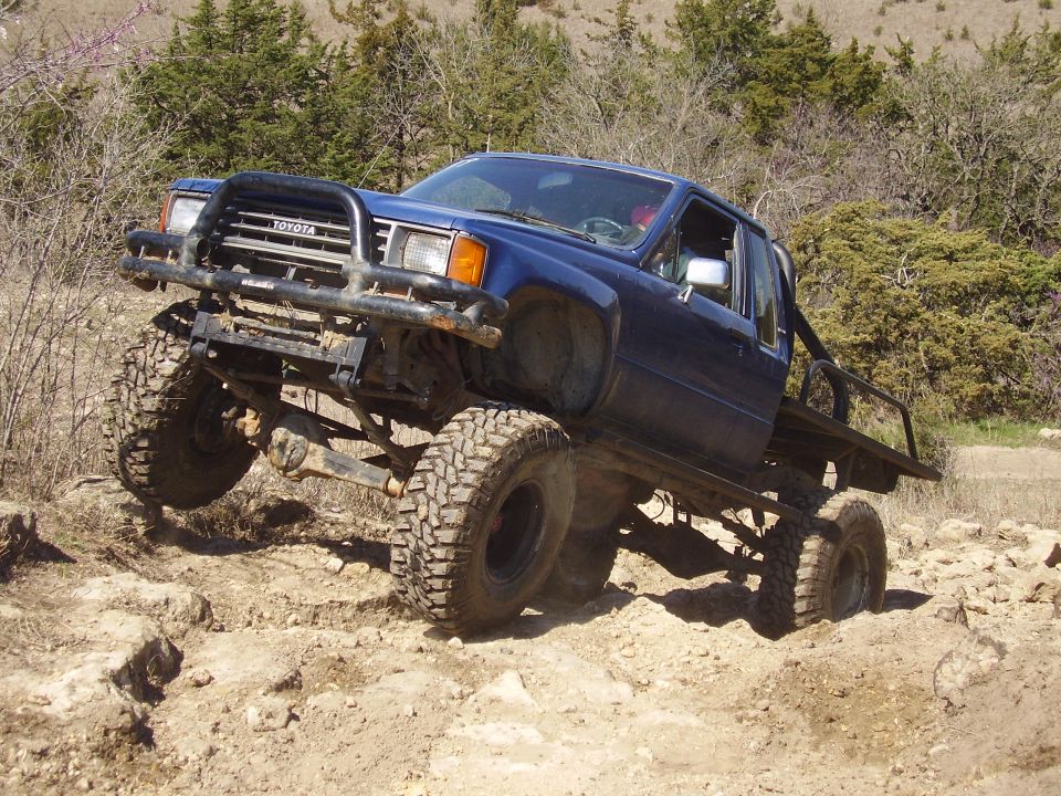 Lifted blue Toyota flatbed truck on rocks