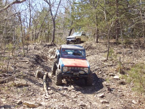 2007 Ford GT - Two off-road vehicles tackle a challenging, rocky path in a wooded environment.