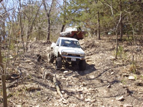 2007 Ford GT - Modified Toyota pickup truck navigates a challenging off-road trail with another vehicle behind it.