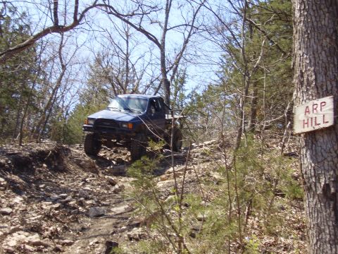 2007 Ford GT - A blue pickup truck navigates a challenging off-road trail marked by a sign that reads ARP HILL.