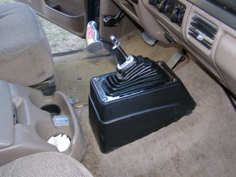 1993 Ford Bronco - Close-up of an aftermarket shifter and EGM knob inside a vehicle's cabin.
