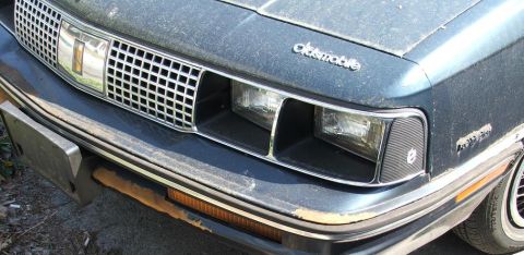 1991 Ford LTD Crown Victoria - Close-up of the front grille and headlights of an Oldsmobile.