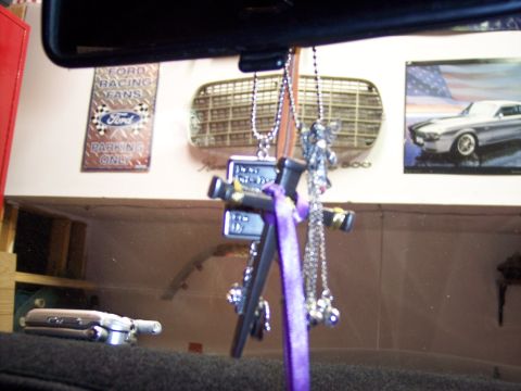 1972 Ford Ranchero - Hanging religious charms and Ford memorabilia are visible inside a vehicle.