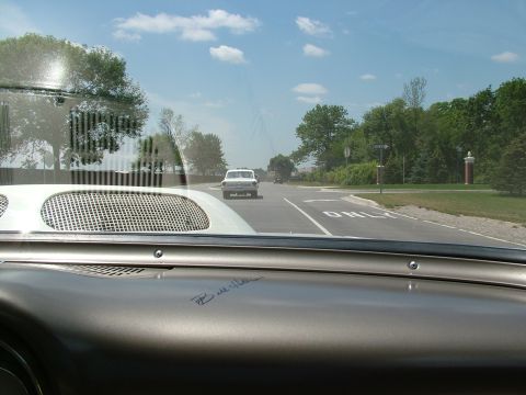 1972 Ford Ranchero - A white 1950s car is visible ahead on the road, viewed from the interior of another car.