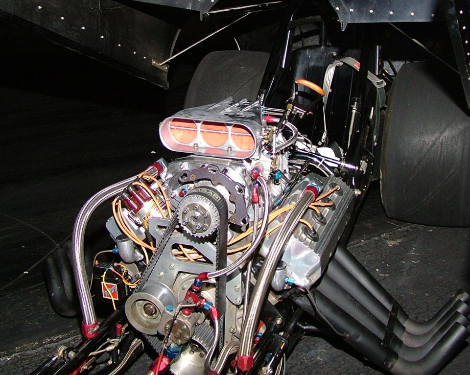 drag racing engine with supercharger, headers, and large tires visible