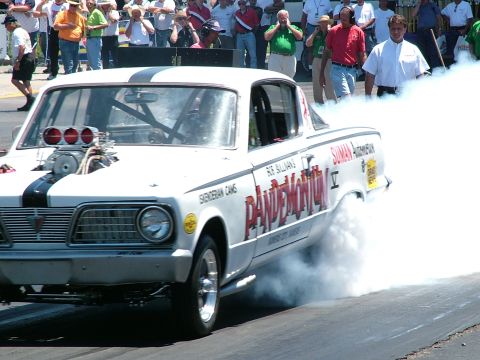 1972 Ford Ranchero - A drag car performs a burnout at a race event, creating a large cloud of smoke.