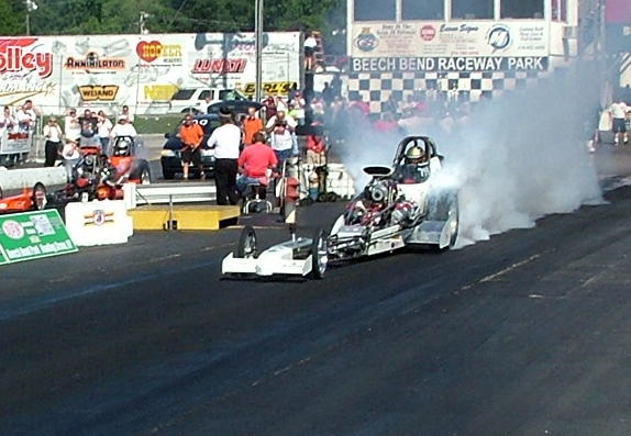 Dragster doing a burnout, front view, white with red accents