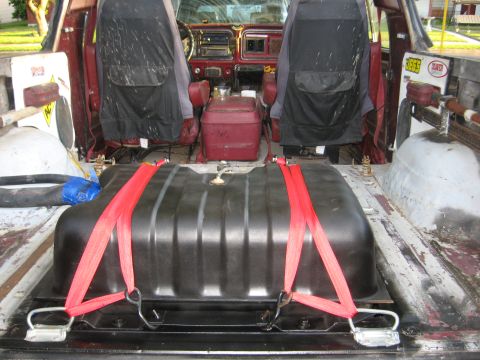 1979 Ford Bronco - The interior of a 1979 Ford Bronco shows a large auxiliary fuel tank secured with red straps in the cargo area.