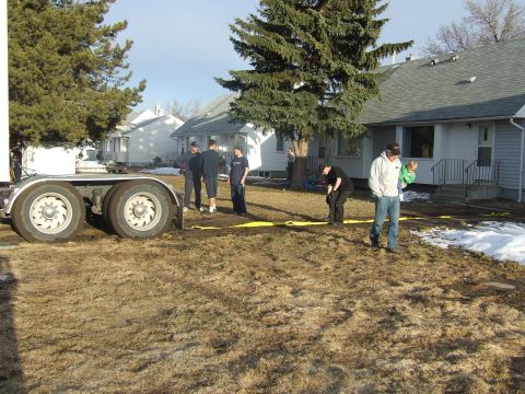 1990 Ford Bronco - People gathered around a trailer in a residential yard during daytime.