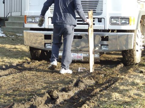 1990 Ford Bronco - Person stands in front of a large truck bumper in muddy terrain. Alberta license plate is visible.
