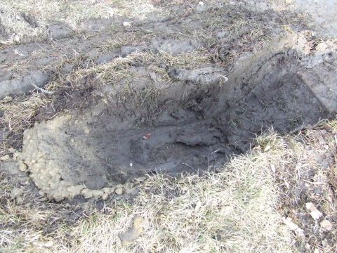 1990 Ford Bronco - Tire tracks are visible in the mud and grass, suggesting a vehicle passed through this area.