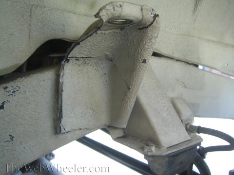 1987 Suzuki Samurai - Close-up view of a modified suspension mounting bracket on a vehicle's frame, likely for a shock swap modification.