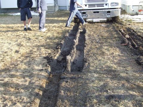 1990 Ford Bronco - Truck has created deep ruts in the muddy ground.