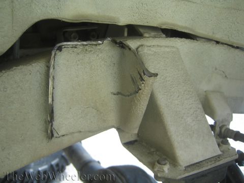 1987 Suzuki Samurai - Close-up view of a modified vehicle frame, showing cut metal and structural components.