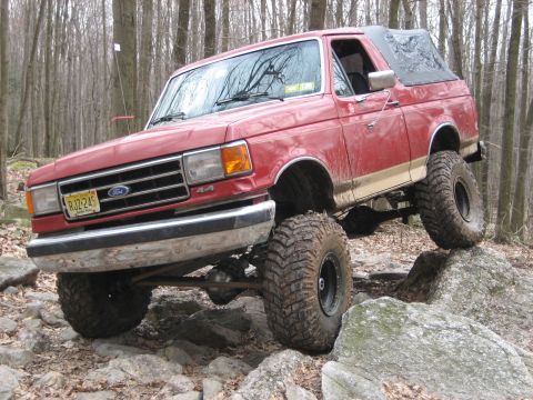 1990 Ford Bronco - This lifted 1990 Ford Bronco navigates a rocky trail with its front tires high in the air.