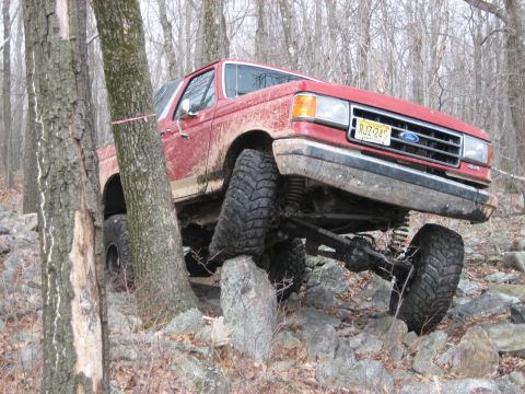 1990 Ford Bronco - This 1990 Ford Bronco is shown tackling a challenging off-road course with large rocks.