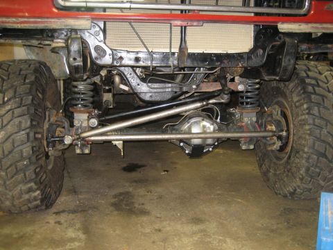 1990 Ford Bronco - Close-up view of a vehicle's front axle and suspension system components.