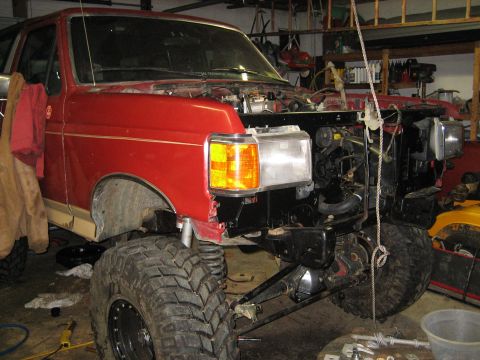 1990 Ford Bronco - Front end of a 1990 Ford Bronco disassembled for repair in a workshop setting.