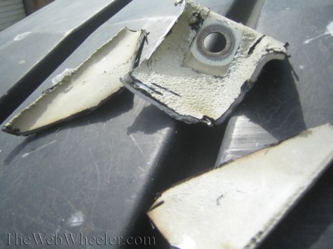 1987 Suzuki Samurai - Damaged vehicle components are scattered on a dark surface.