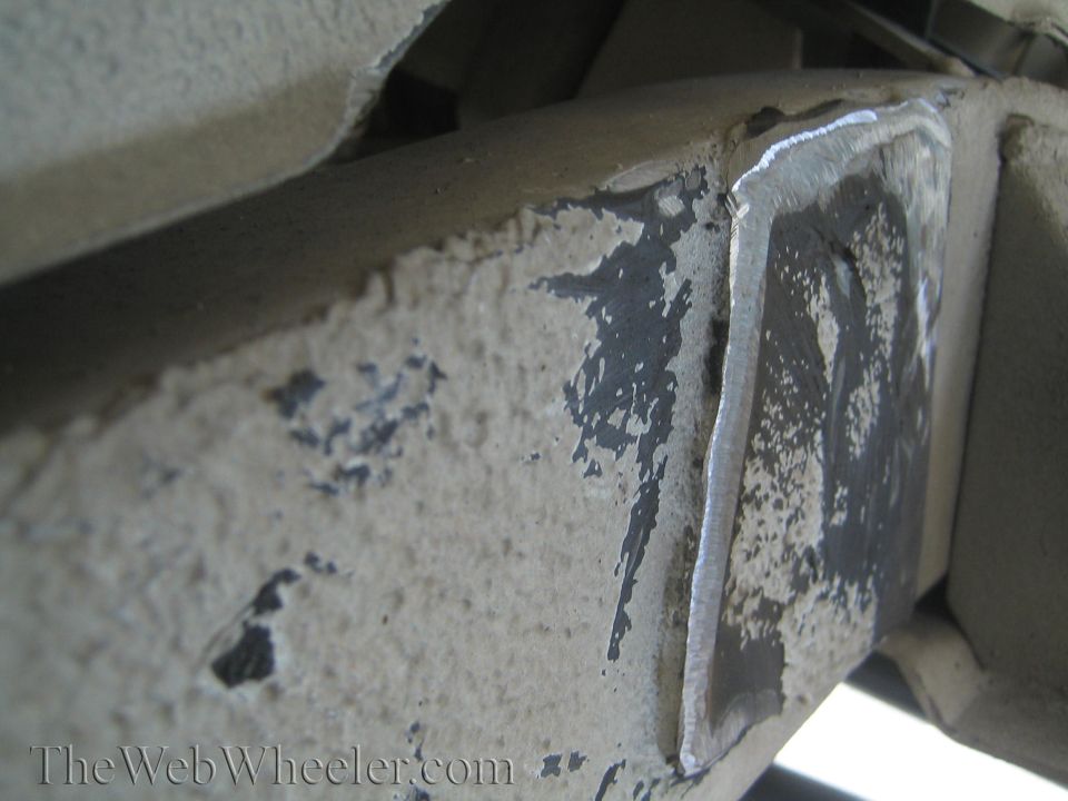 close-up of a welded metal frame section with chipped paint