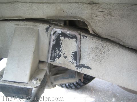 1987 Suzuki Samurai - Close-up of a modified vehicle frame, showing a welded metal plate on the chassis.