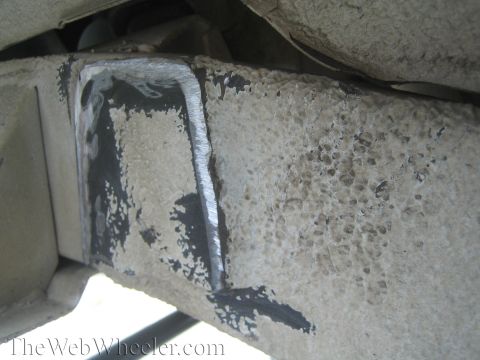 1987 Suzuki Samurai - Detail of a vehicle's frame showing modifications, possibly for a suspension upgrade.