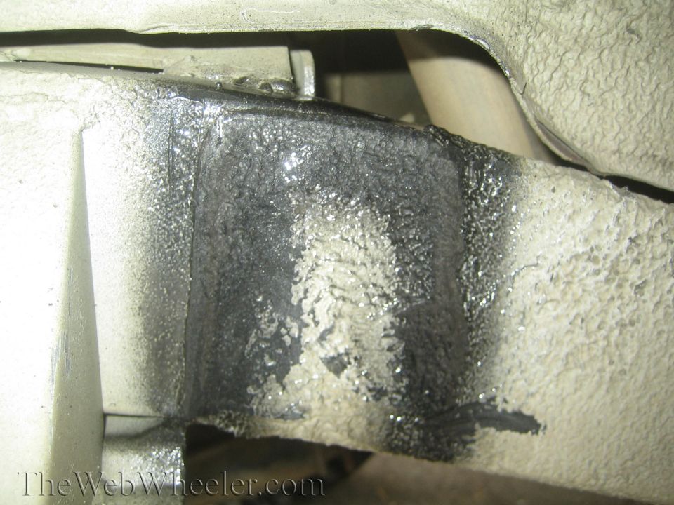 close-up of vehicle frame with black undercoating
