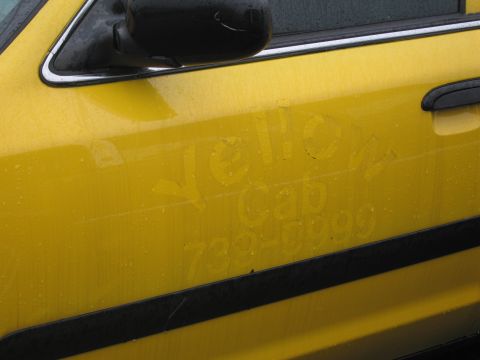 1991 Ford LTD Crown Victoria - A yellow taxi door shows faded lettering for "Yello Cab" and a phone number.