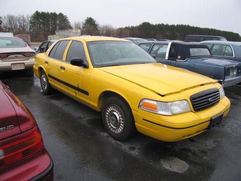 1991 Ford LTD Crown Victoria - A yellow 1991 Ford Crown Victoria LTD taxi is parked in a lot with other vehicles.