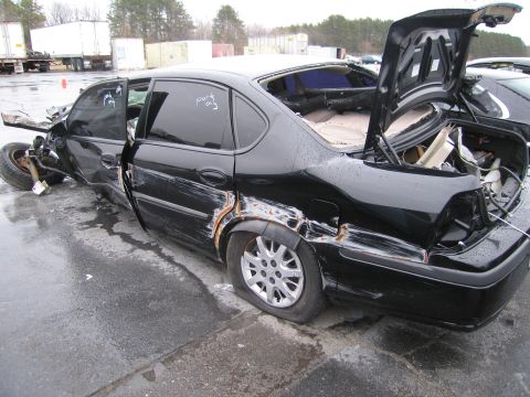 1991 Ford LTD Crown Victoria - This heavily damaged sedan has its doors ajar and flat tires, indicating a severe collision.