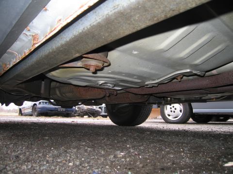 1991 Ford LTD Crown Victoria - Underside of a car, showing rust and exhaust. Multiple vehicles in background.