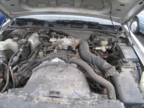 1991 Ford LTD Crown Victoria - The engine bay of a 1991 Ford Crown Victoria, showing the V8 engine and associated components under the hood.