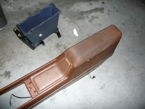 1975 Ford Ranchero - A brown car center console and a black trash bin are shown on a concrete floor.