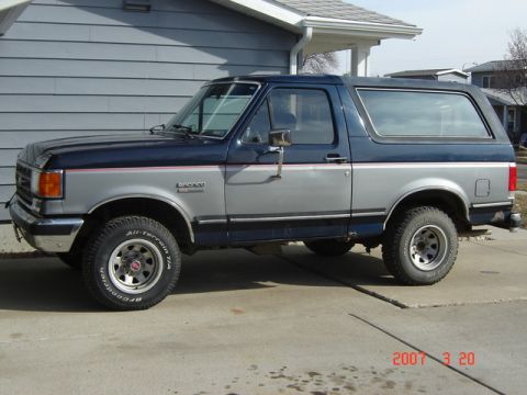 1988 Ford Bronco - This 1988 Ford Bronco features a two-tone blue and silver paint scheme with a side profile view.