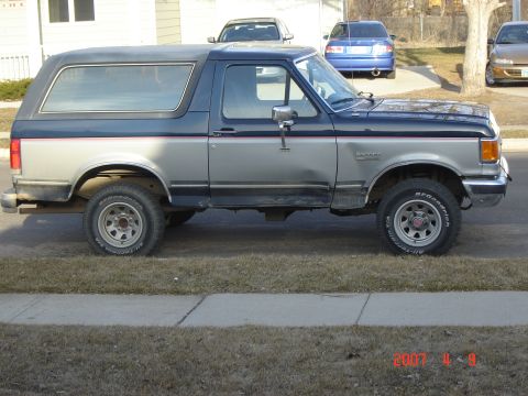 1988 Ford Bronco - This Ford Bronco has a two-tone paint scheme with a silver lower body and a dark blue upper body and roof.