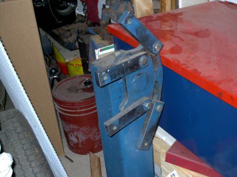 1965 Ford Mustang - A blue metal shear tool is shown in a cluttered garage setting with various items like a tire and buckets.