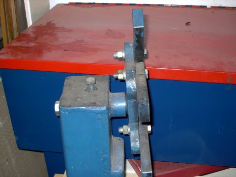 1965 Ford Mustang - A close-up view of a metal bracket and bolts, with a storage cabinet in the background.