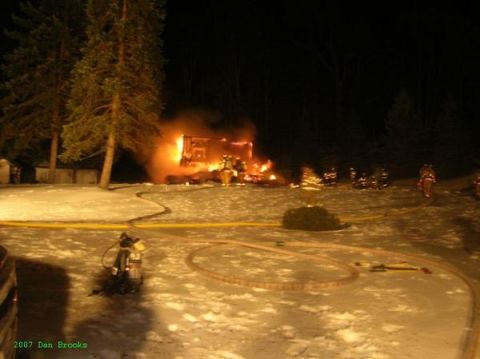 1989 Ford Bronco - Firefighters battle a blaze at a structure on a snowy night, with hoses and equipment visible.