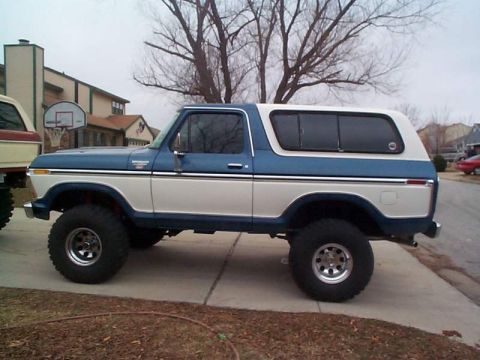 1978 Ford Bronco - Side view of a lifted 1978 Ford Bronco with a two-tone blue and white paint scheme.