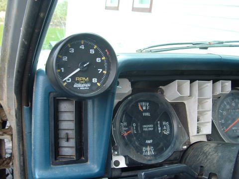 1983 Ford Ranger - Close-up of a vehicle's dashboard, showing an AutoGauge tachometer and a multi-function gauge with fuel, oil, and temperature readings.