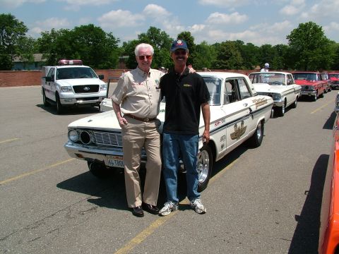 1972 Ford Ranchero - Two men pose with a classic white Ford Falcon, possibly at a car show, with other vehicles lined up in the background.