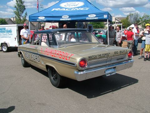 1972 Ford Ranchero - A gold 1963 Ford Ranchero with a black roof and 'Thunderbolt' graphics is parked under a Ford Racing tent.