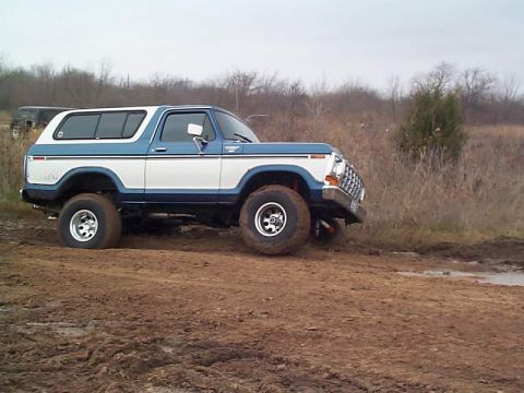 1978 Ford Bronco - This 1978 Ford Bronco is shown off-road on a muddy path with dry brush in the background.