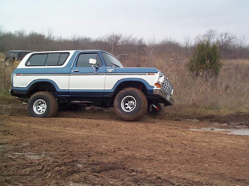 1978 Ford Bronco driving on a muddy trail