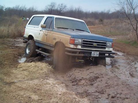1978 Ford Bronco - This two-tone Ford Bronco is navigating a muddy, off-road terrain.