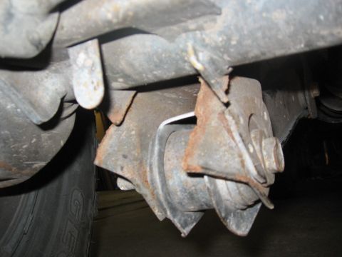 1974 Ford F-100 - Close-up view of a heavily rusted suspension part, showing wear and tear.